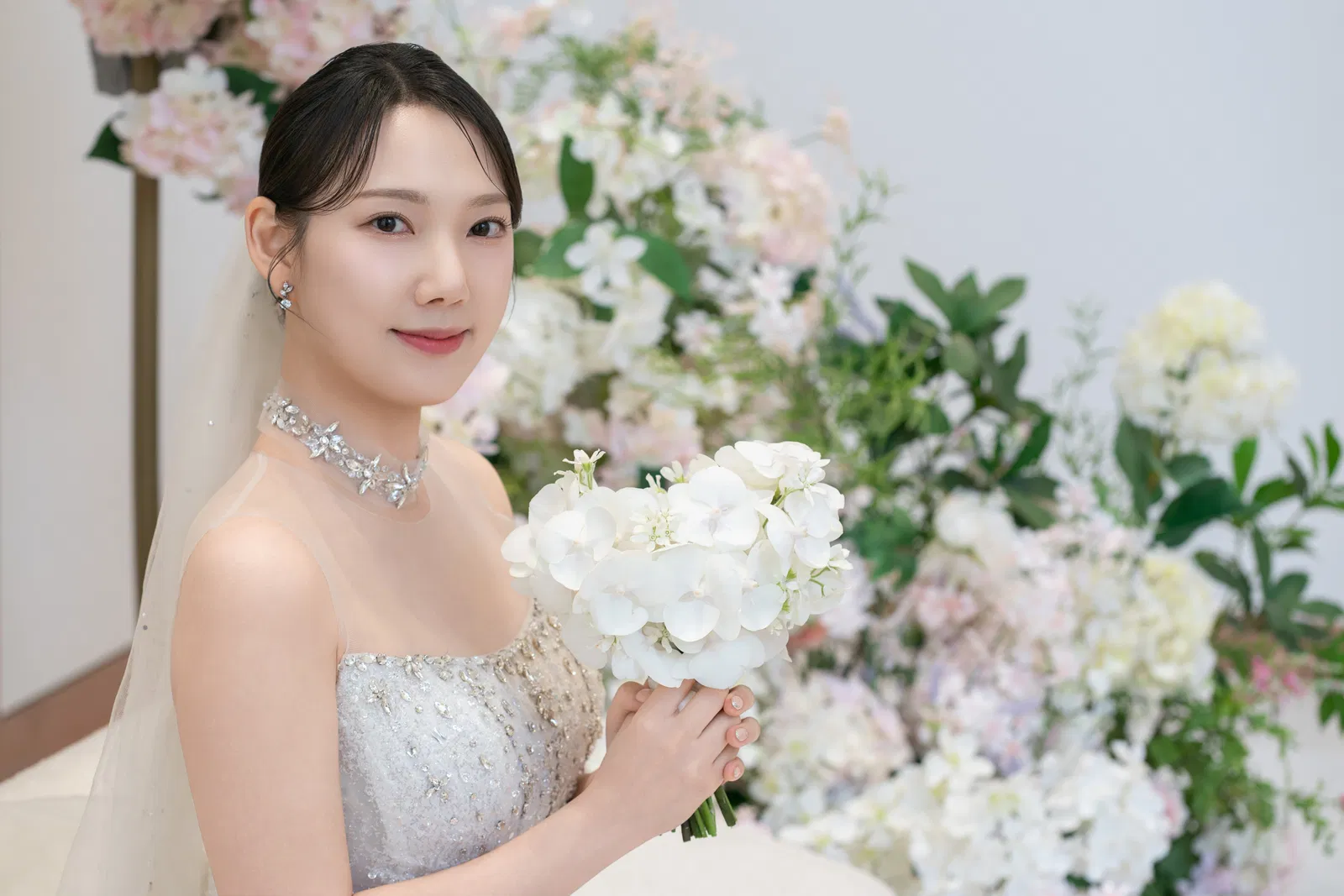 라마다호텔 송도점 흰 꽃 부케를 들고 카메라를 바라보는 신부의 상반신 사진