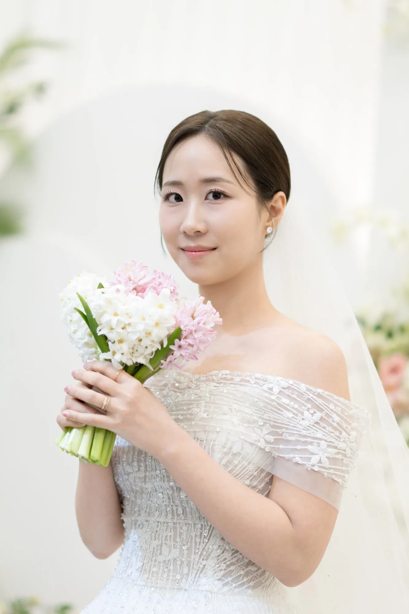 평택 엔팰리스에서 흰색과 분홍빛 부케를 들고 정면을 바라보는 신부