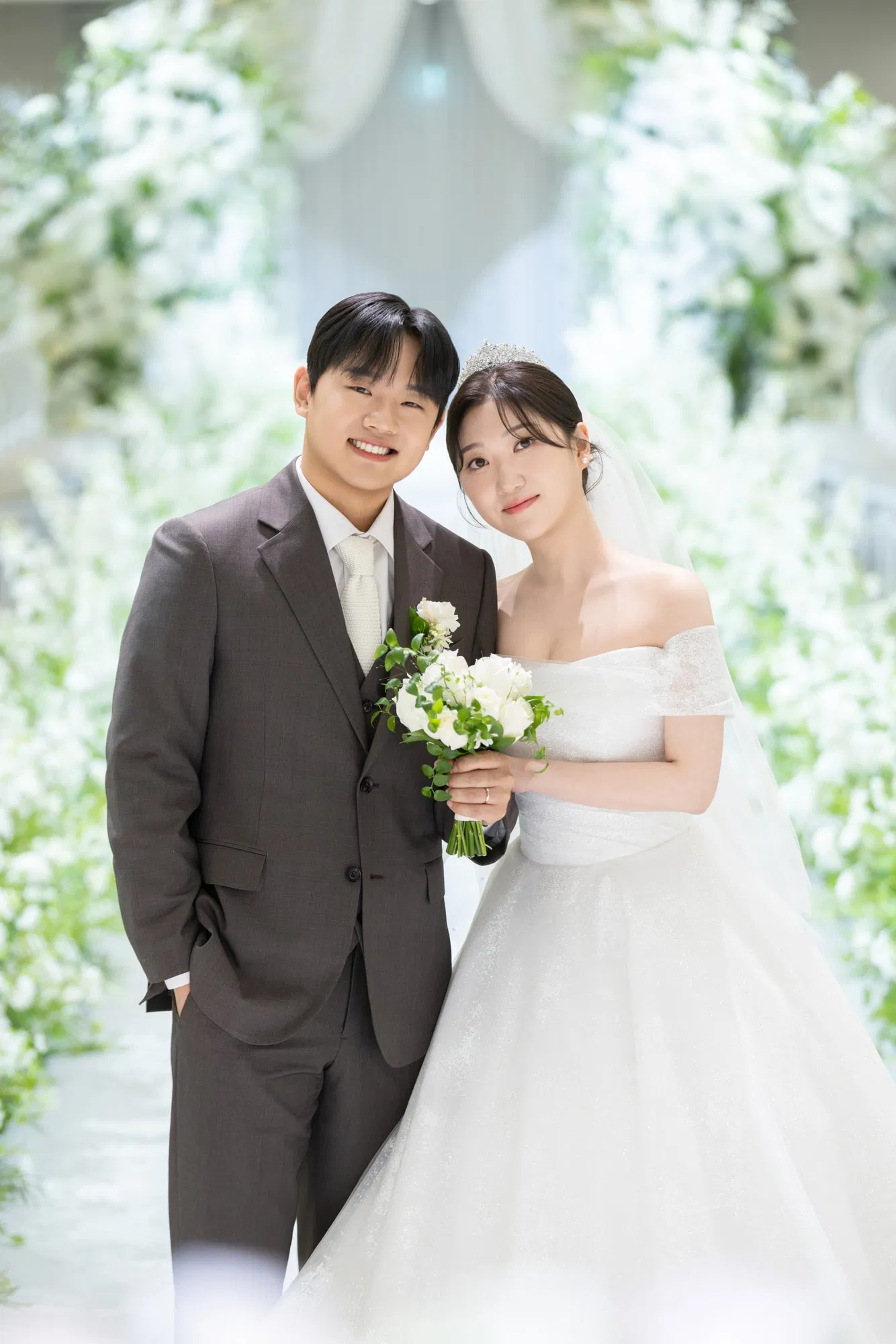 솔스퀘어컨벤션 흰 꽃길에서 서로 기대어 선 신랑신부