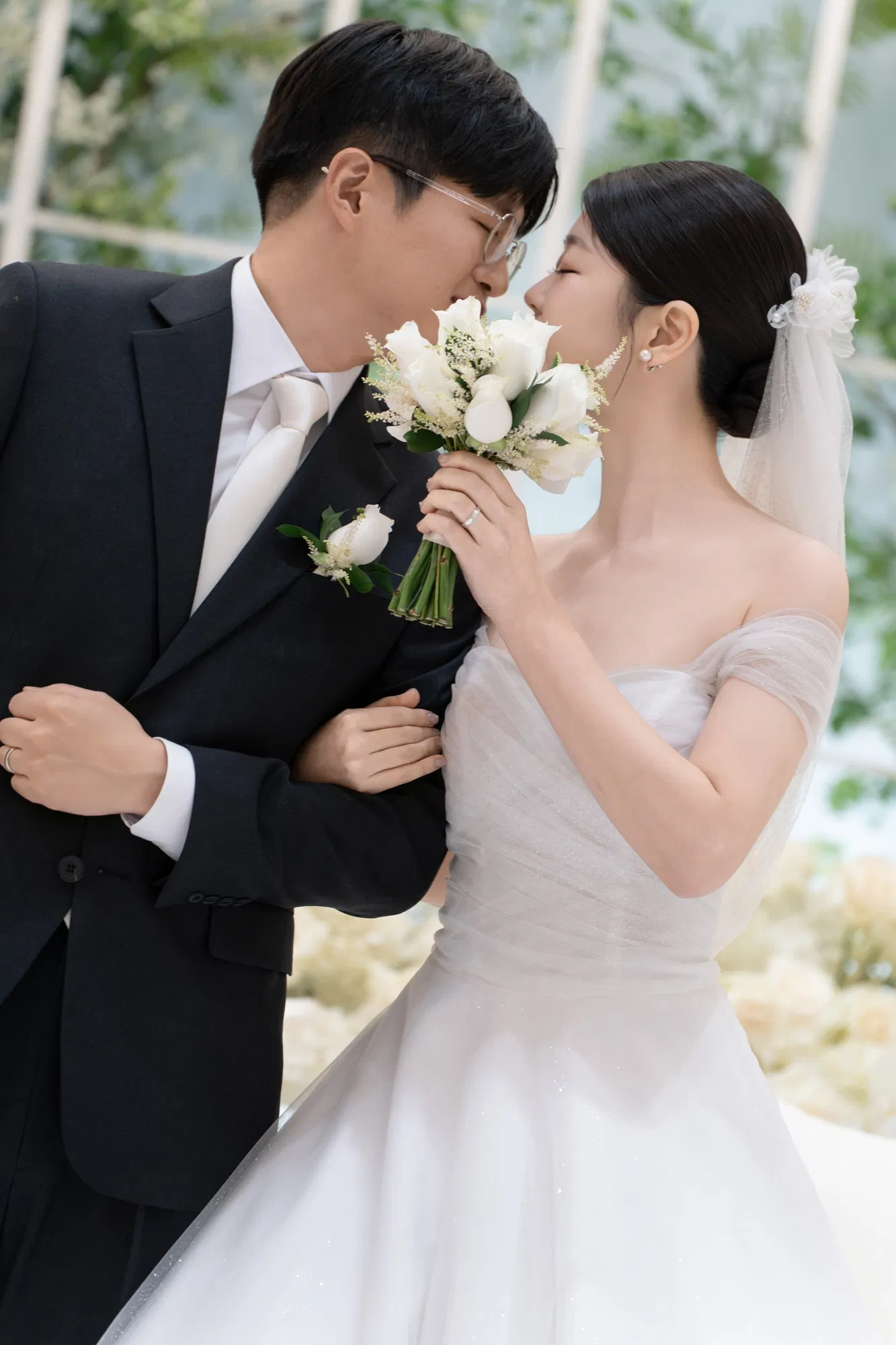 스타시티아트홀에서 흰 부케 너머로 얼굴을 가까이 마주한 신랑신부