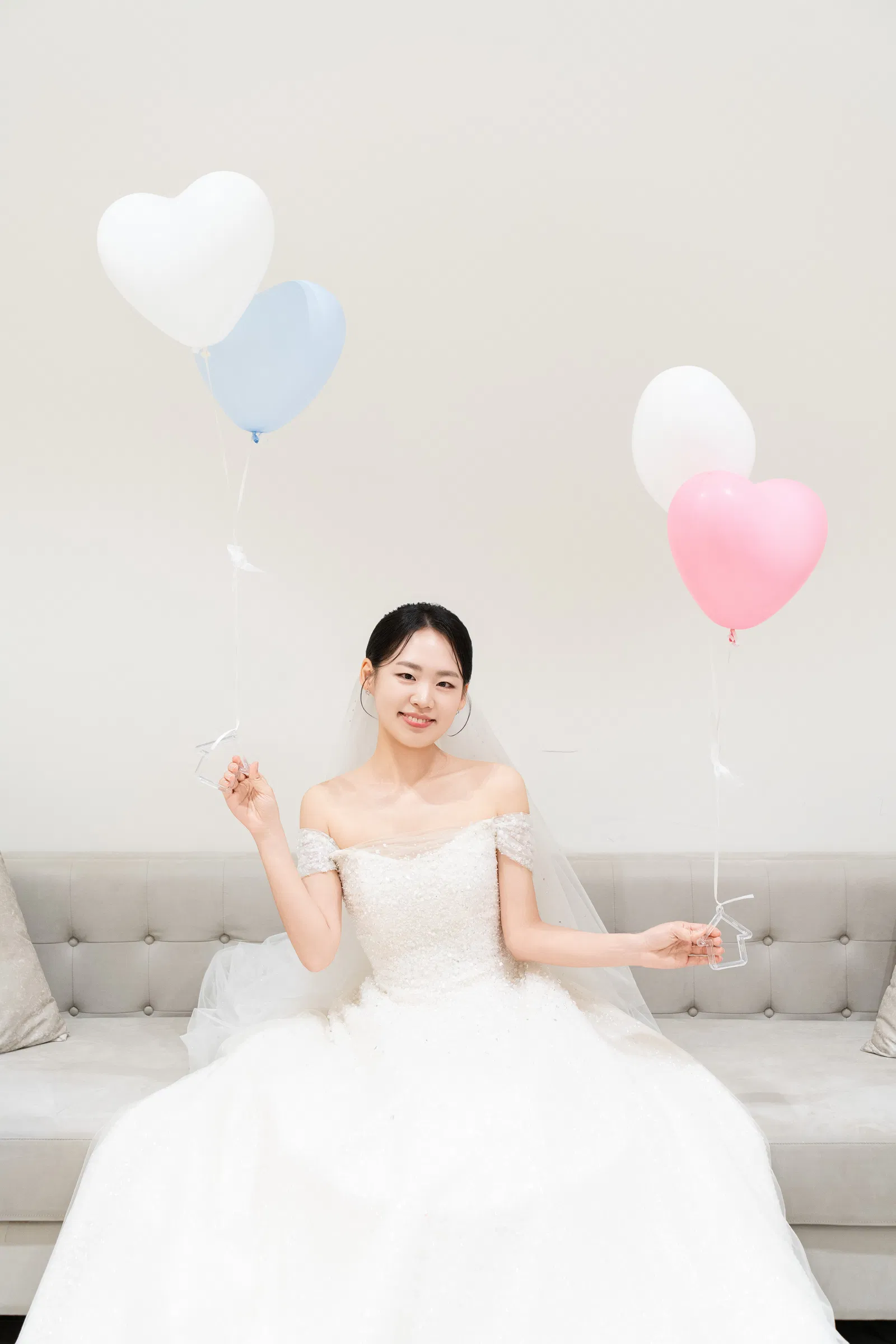 더 베뉴지 서울, 하트 풍선 옆 소파에 앉아 미소 짓는 신부